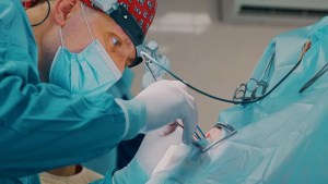 Oral surgeon performing a precise dental procedure in a sterile operating room at Premier Oral and Maxillofacial Surgery group.