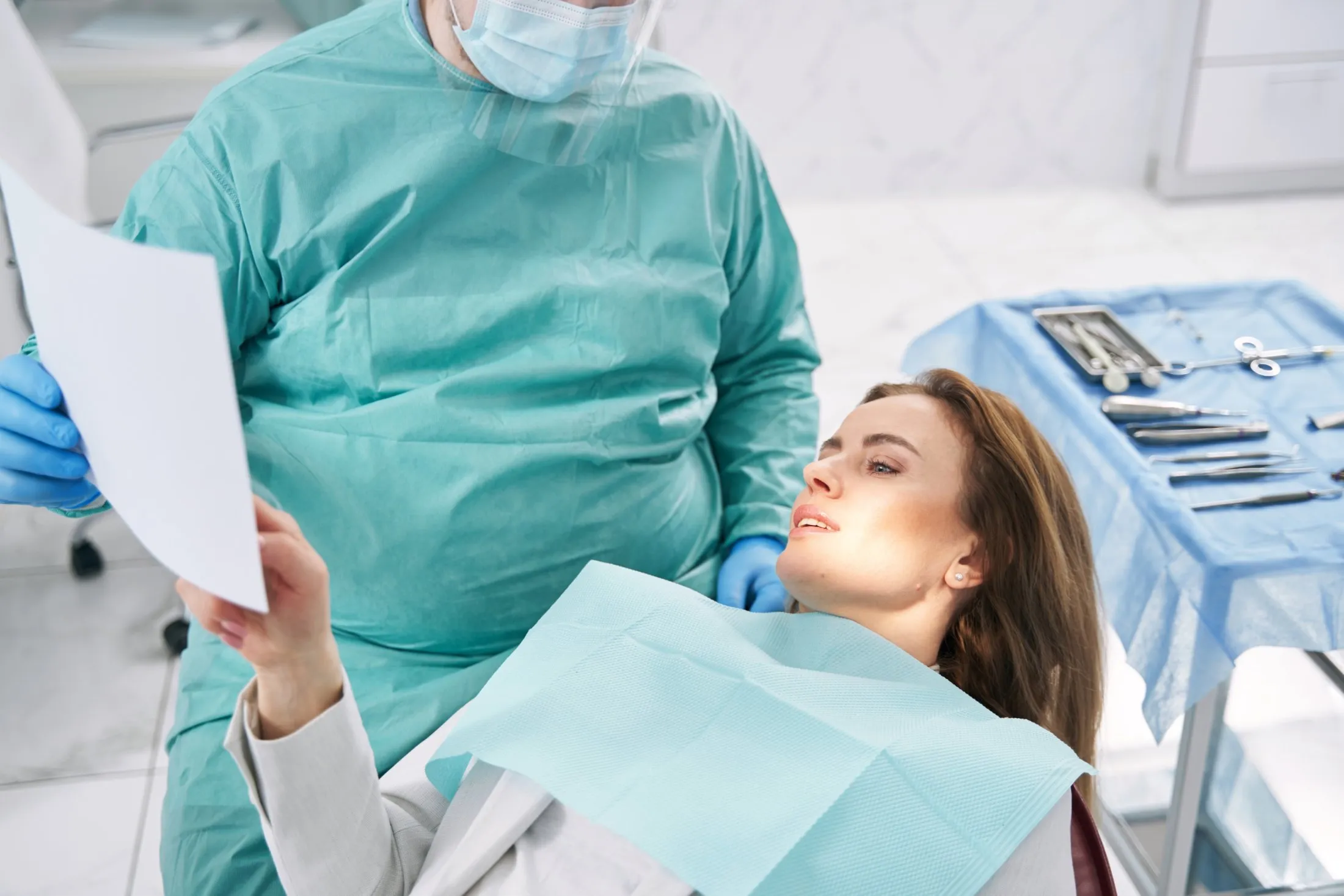 Oral surgeon reviewing 3D dental scan results with a patient while discussing surgical planning and recovery expectations.