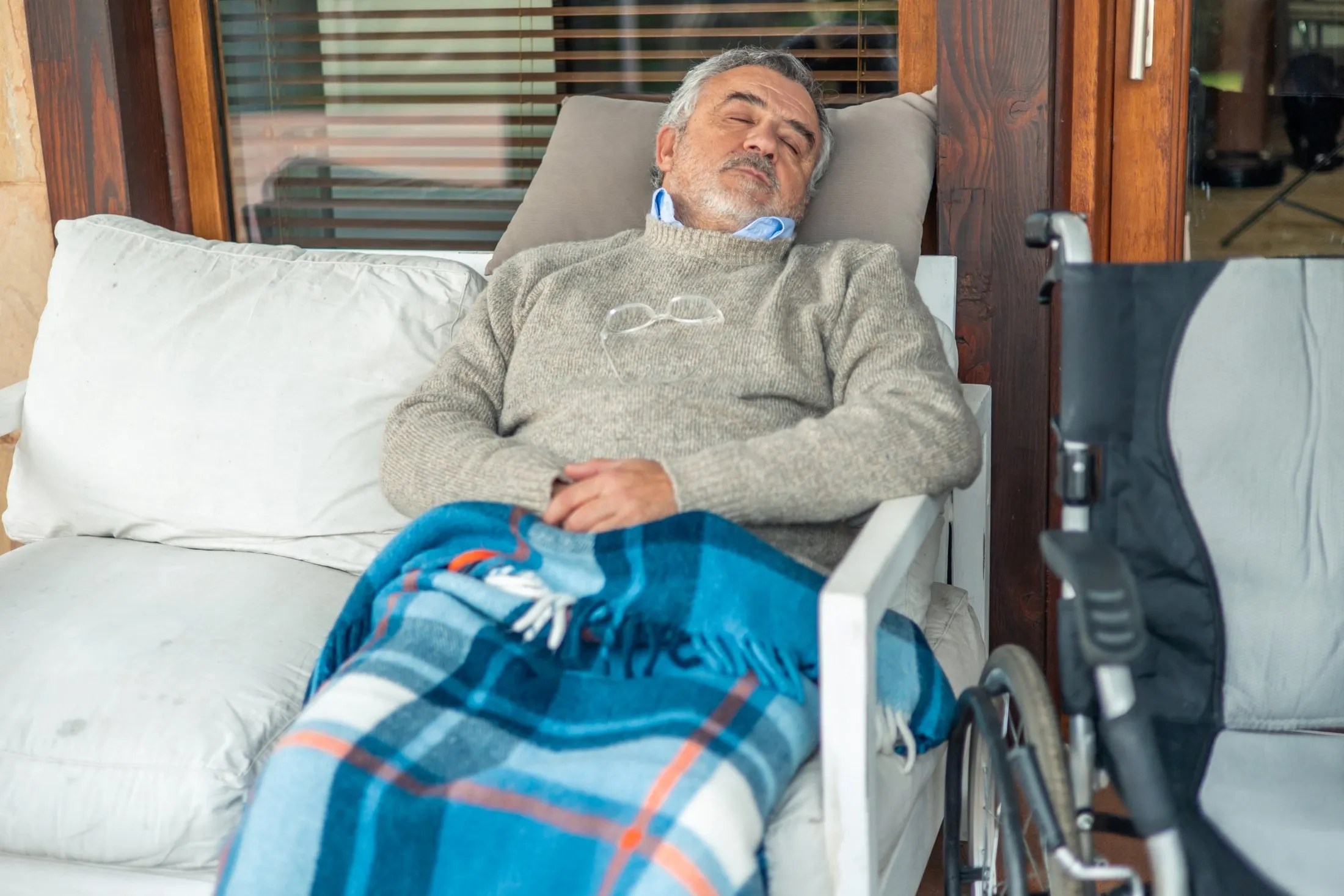 Patient resting comfortably indoors under a blanket during post-surgery recovery in winter.