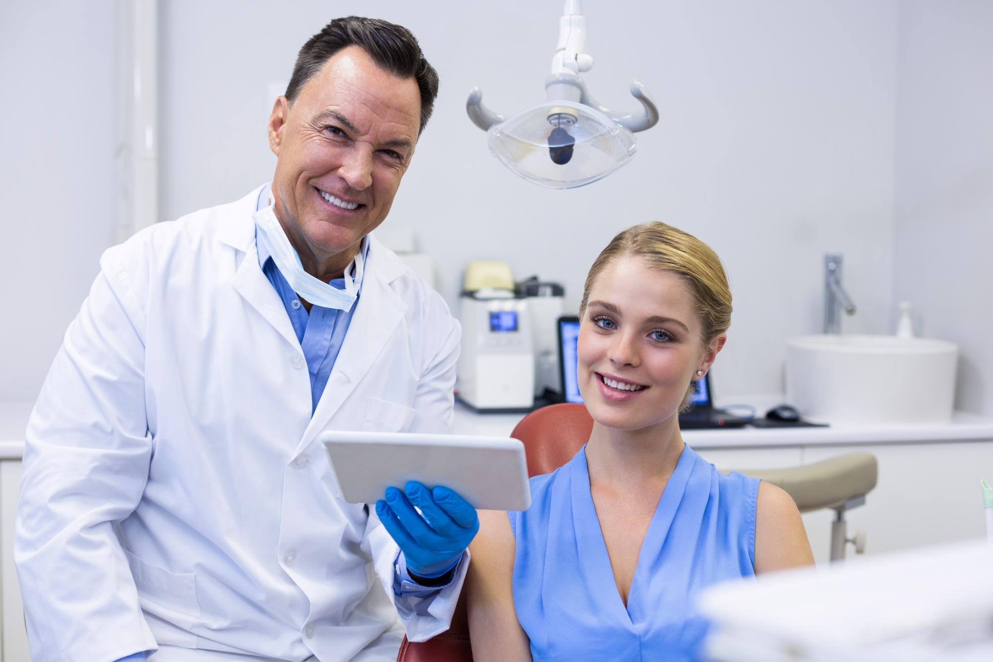 Oral surgeon and patient reviewing treatment plan together in a dental exam room.