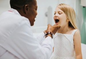 Premier Oral’s dental surgeon examines a child.