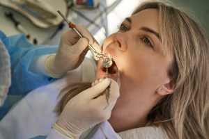 Close-up of a dentist examining a patient at a Premier Oral and Maxillofacial Surgery Group Clinic.