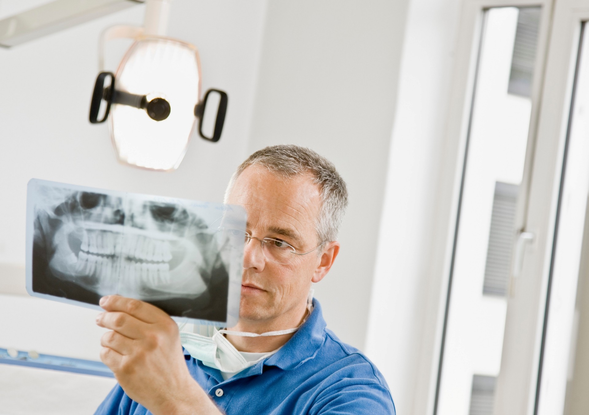 Dentist examining the jaw before dental implants at Premier Oral.