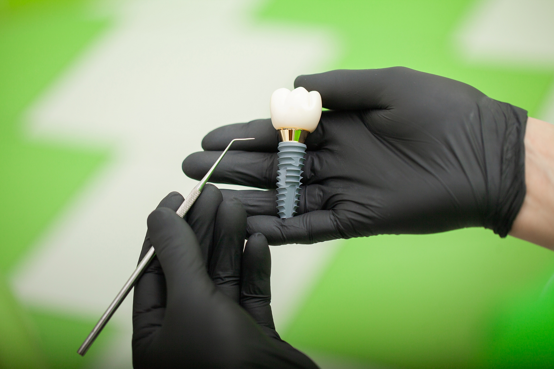 Dental Implant and Instrument in gloved hands at Premier Oral.