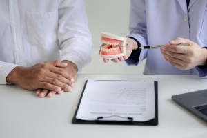 Oral surgeon explaining jaw alignment and treatment options to patient during consultation at Premier Oral.