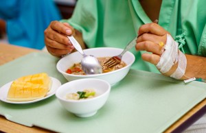 Patient eating soft foods during recovery after oral surgery or dental procedure at Premier Oral.