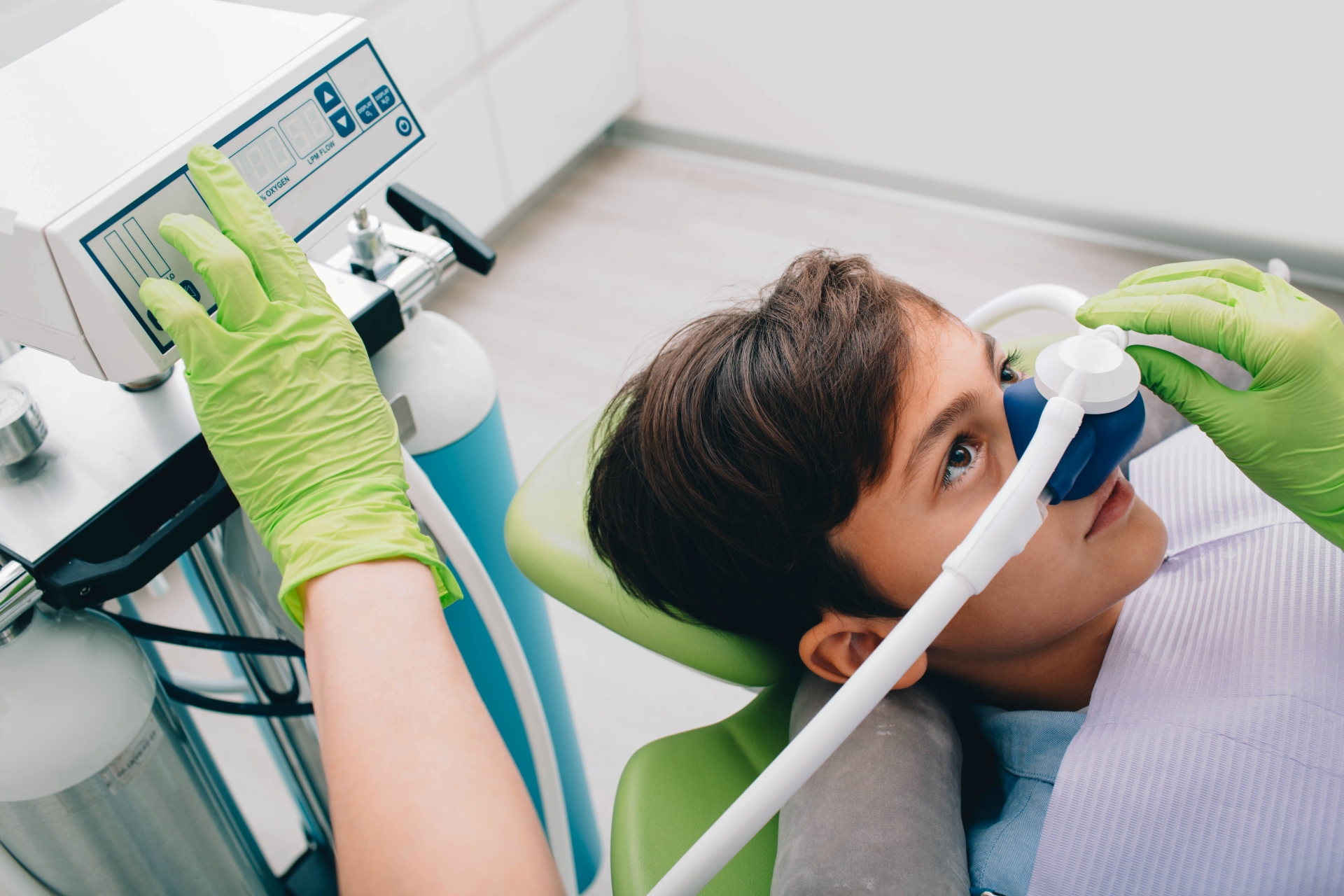 Patient receiving nitrous oxide through nasal mask while relaxed in dental chair at Premier Oral.