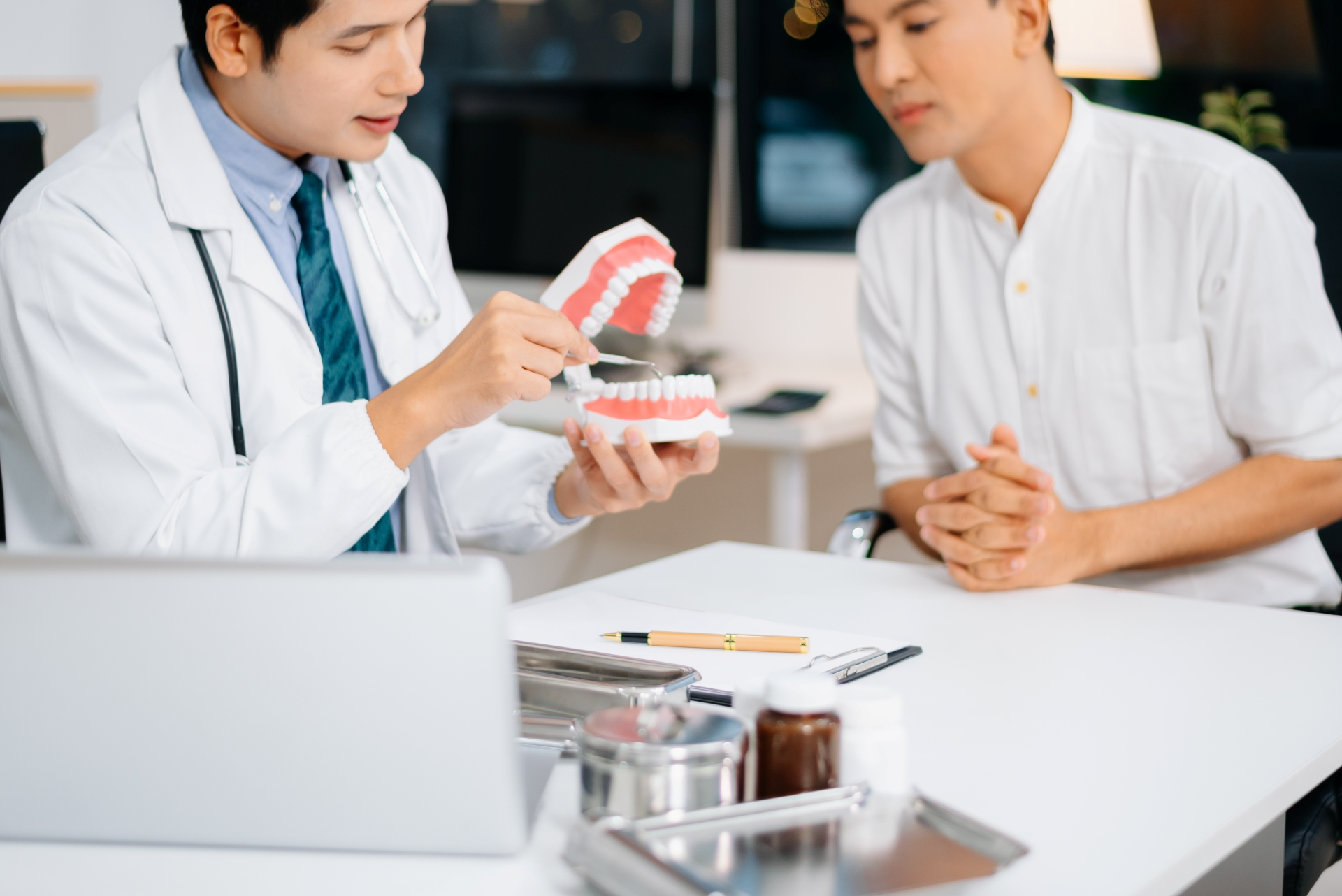 Oral surgeon explaining jaw alignment and treatment plan to patient during consultation.