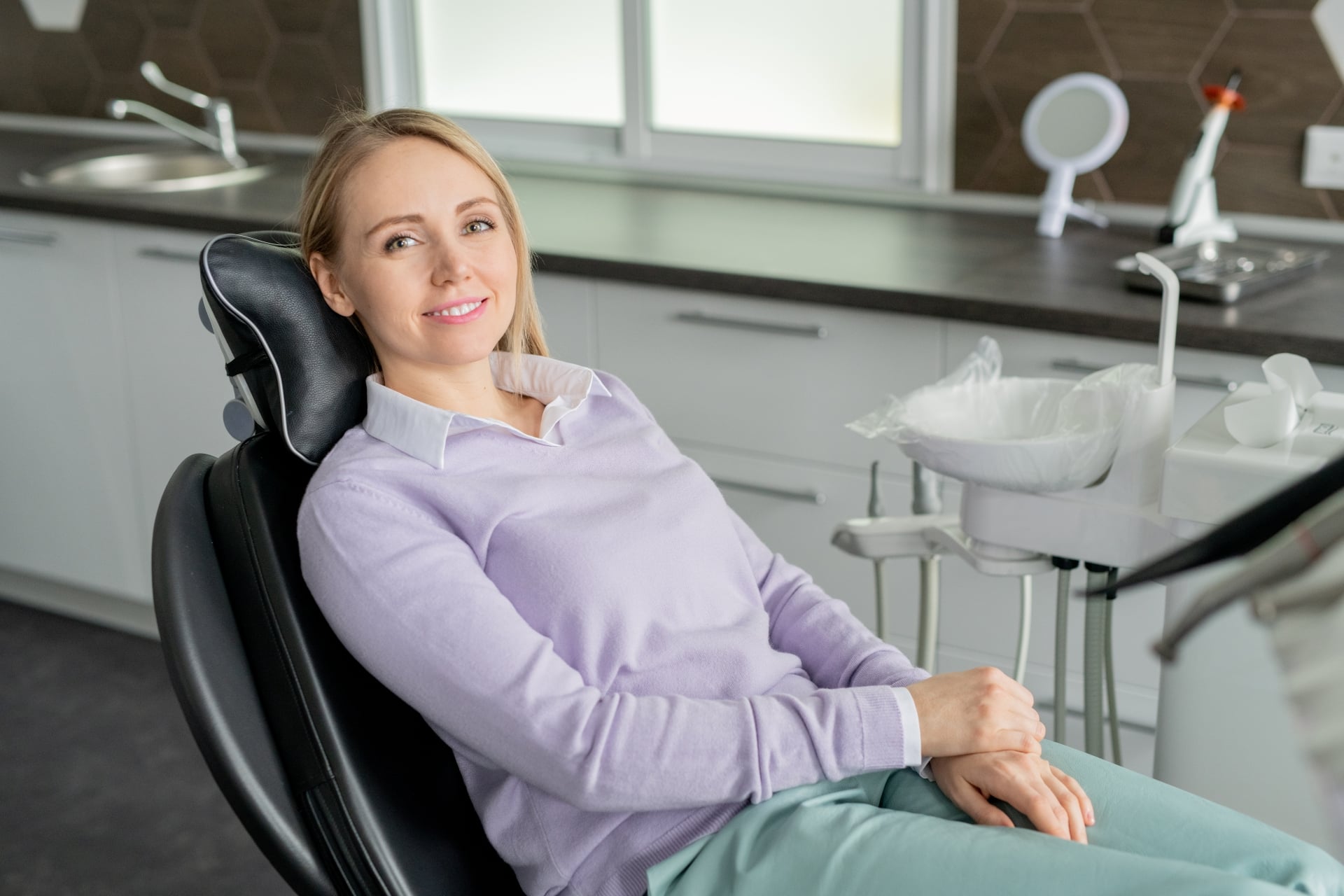 Smiling dental implant patient relaxing comfortably in a dental chair during a consultation visit. 