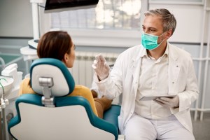Oral surgeon discussing dental implant treatment options with a patient during a consultation appointment.