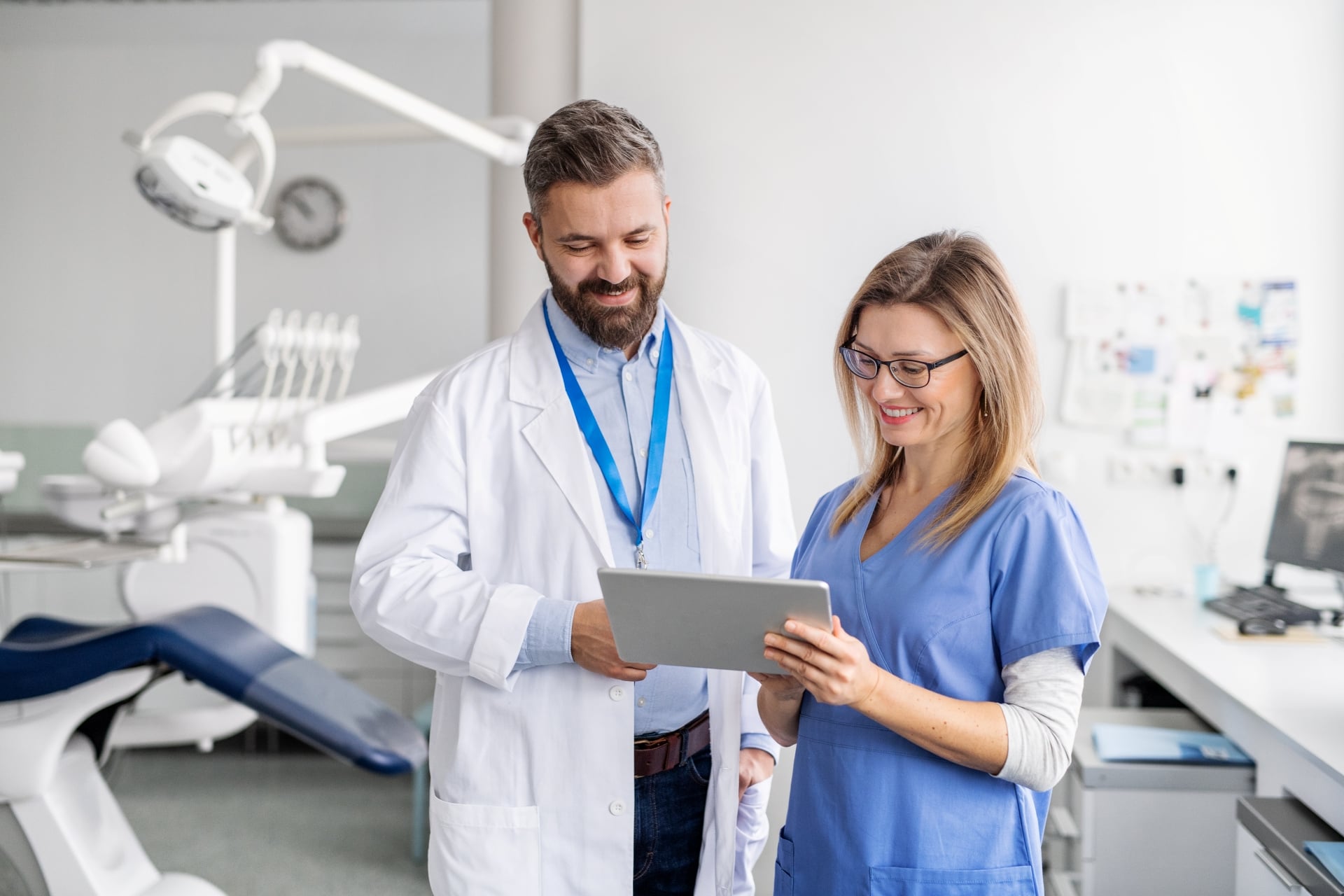 Premier Oral medical professionals reviewing a digital tablet in a modern office.