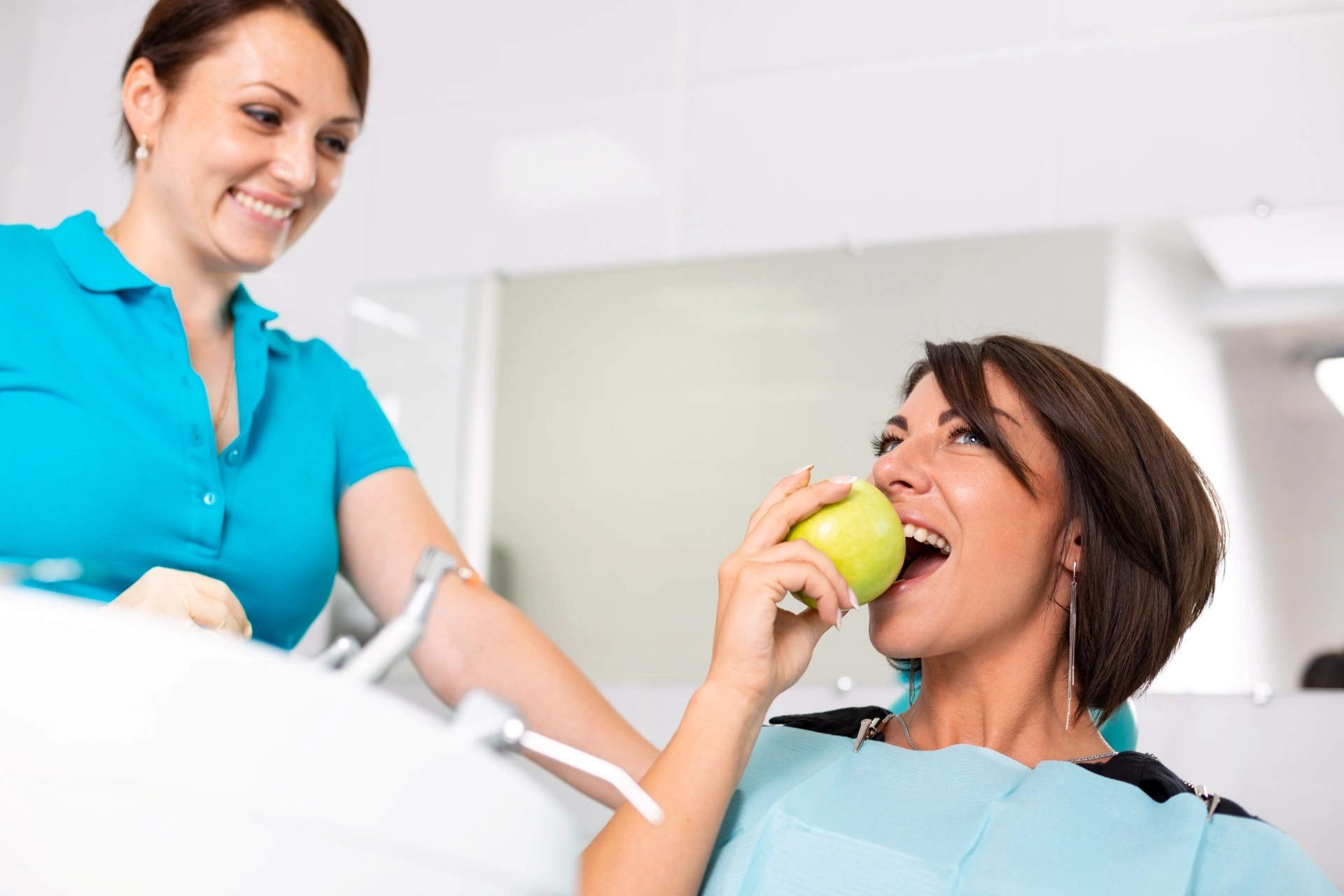 Patient biting into an apple after dental treatment to demonstrate comfortable chewing and restored tooth function.