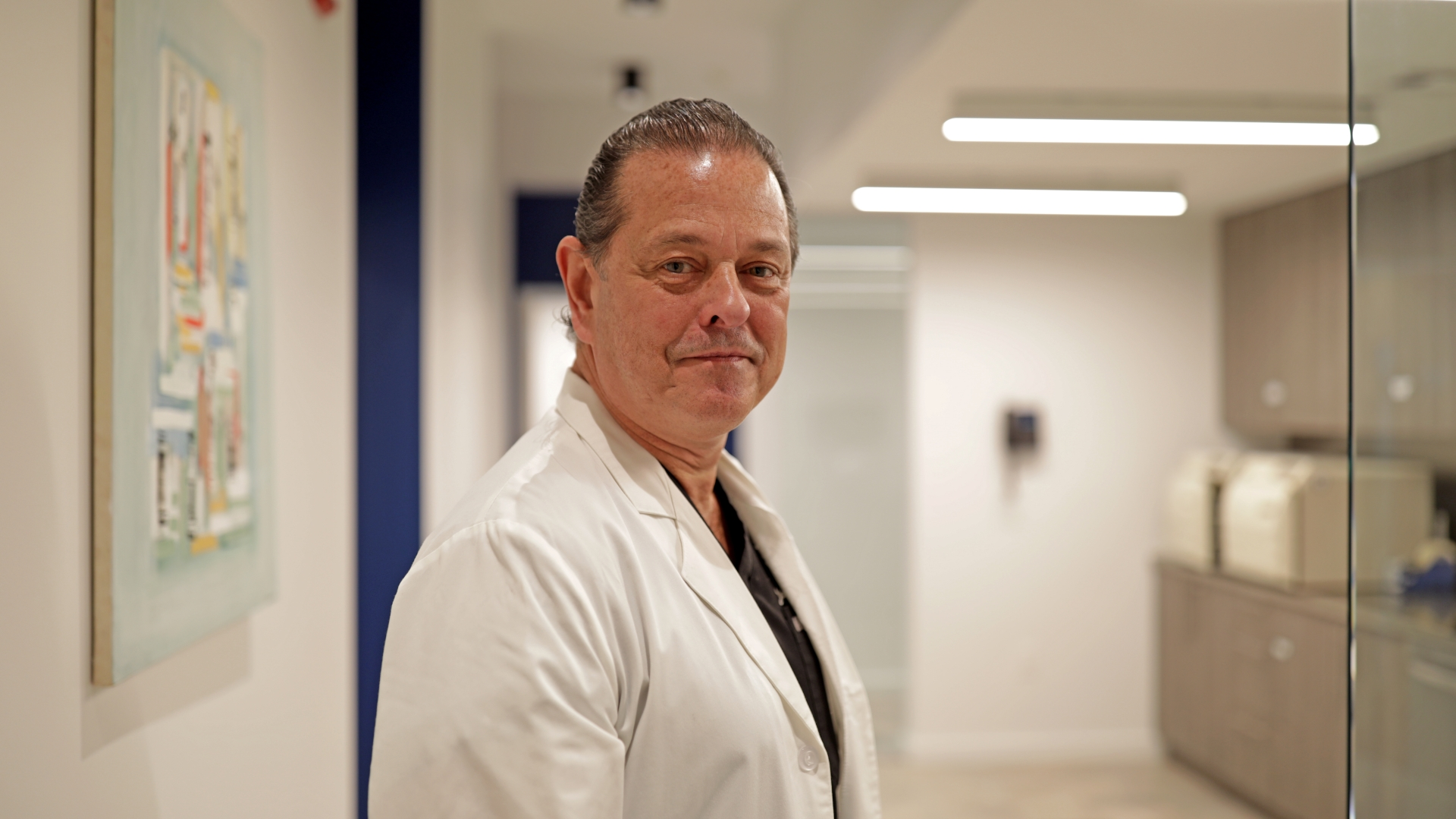 A Premier Oral and Maxillofacial Surgery Group dental surgeon standing in a clinic hallway.