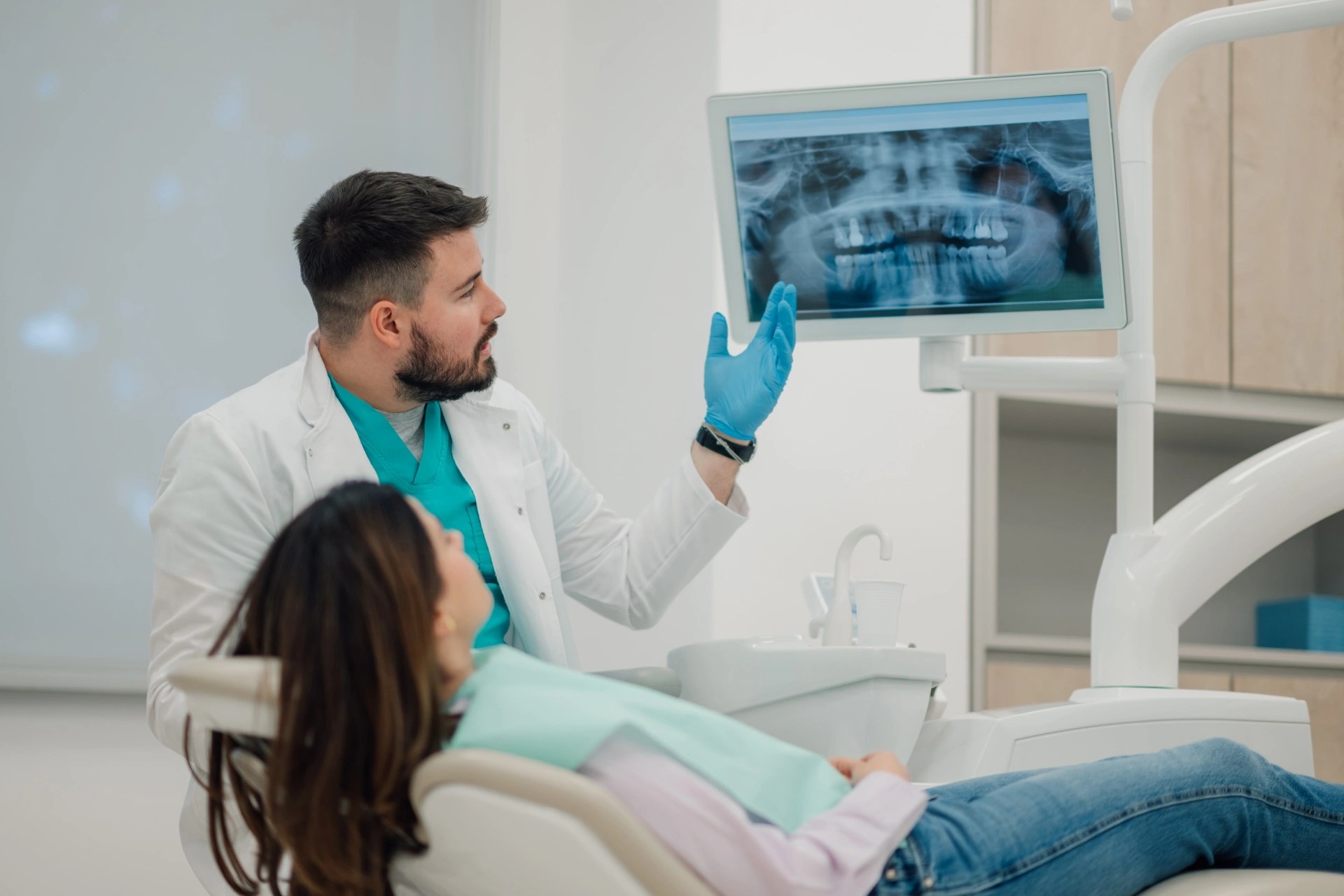 Oral surgeon explaining a dental X-ray to a patient during a consultation. 