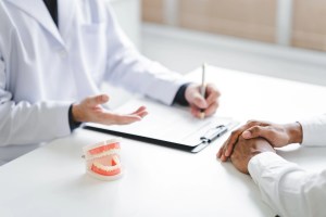 Premier Oral doctor explaining treatment options using a dental model.