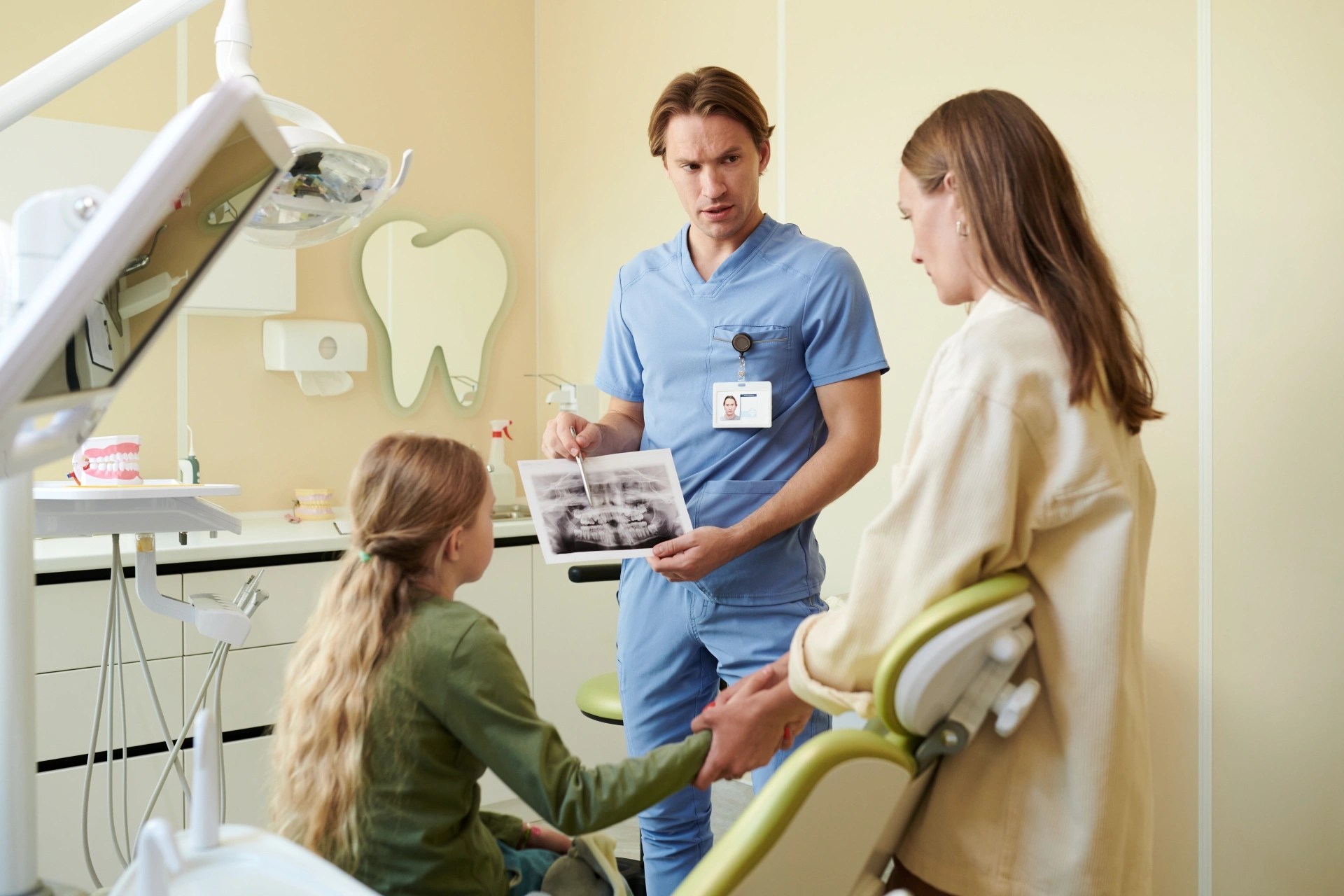 Oral surgeon reviewing dental imaging with a child's parent at Premier Oral.