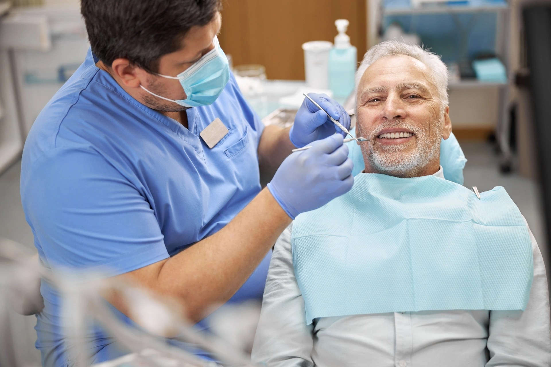 Older patient receiving a dental examination from a dentist during an oral health visit. 