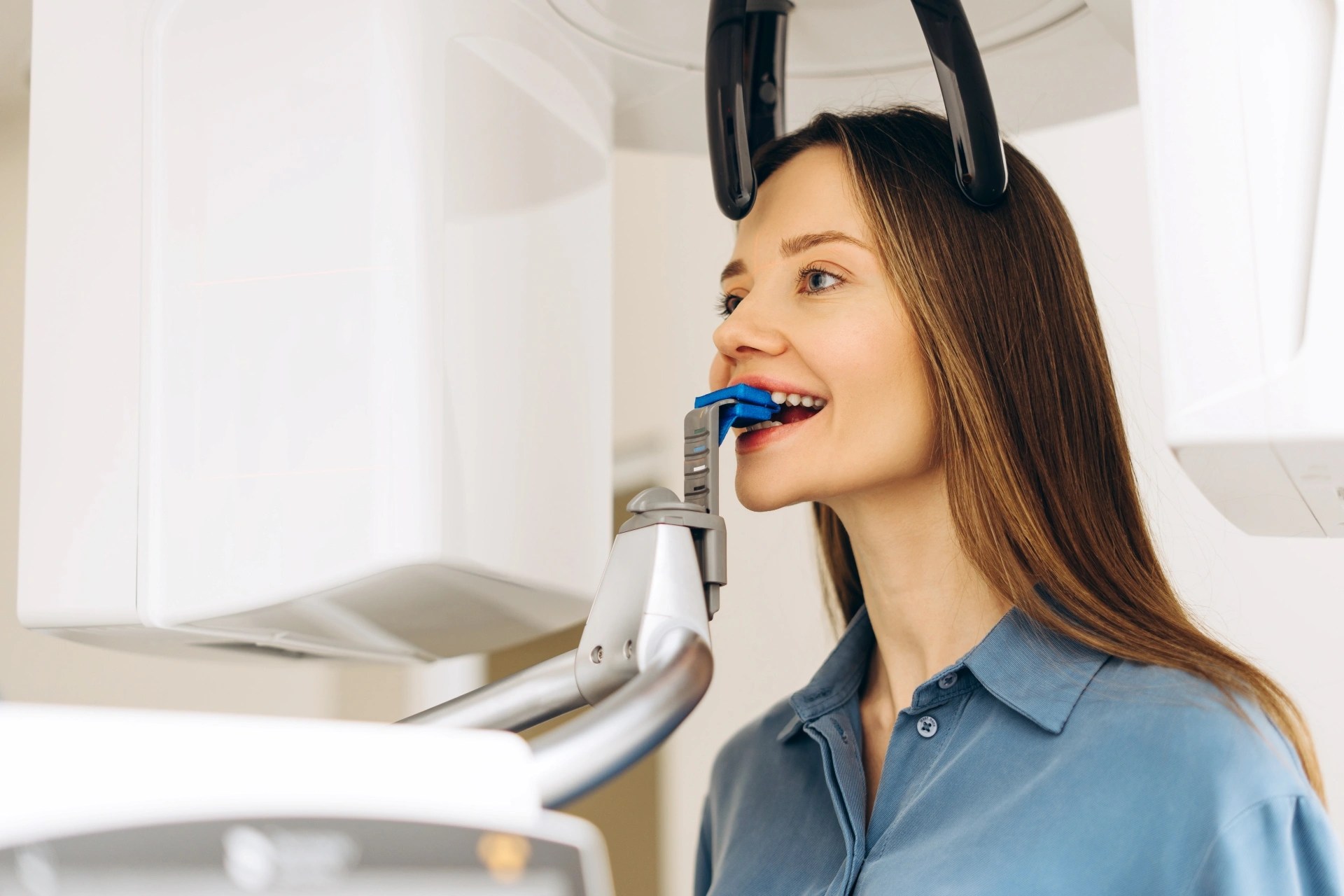 Patient uses 3D dental X-ray bite block device during a diagnosis at Premier Oral.