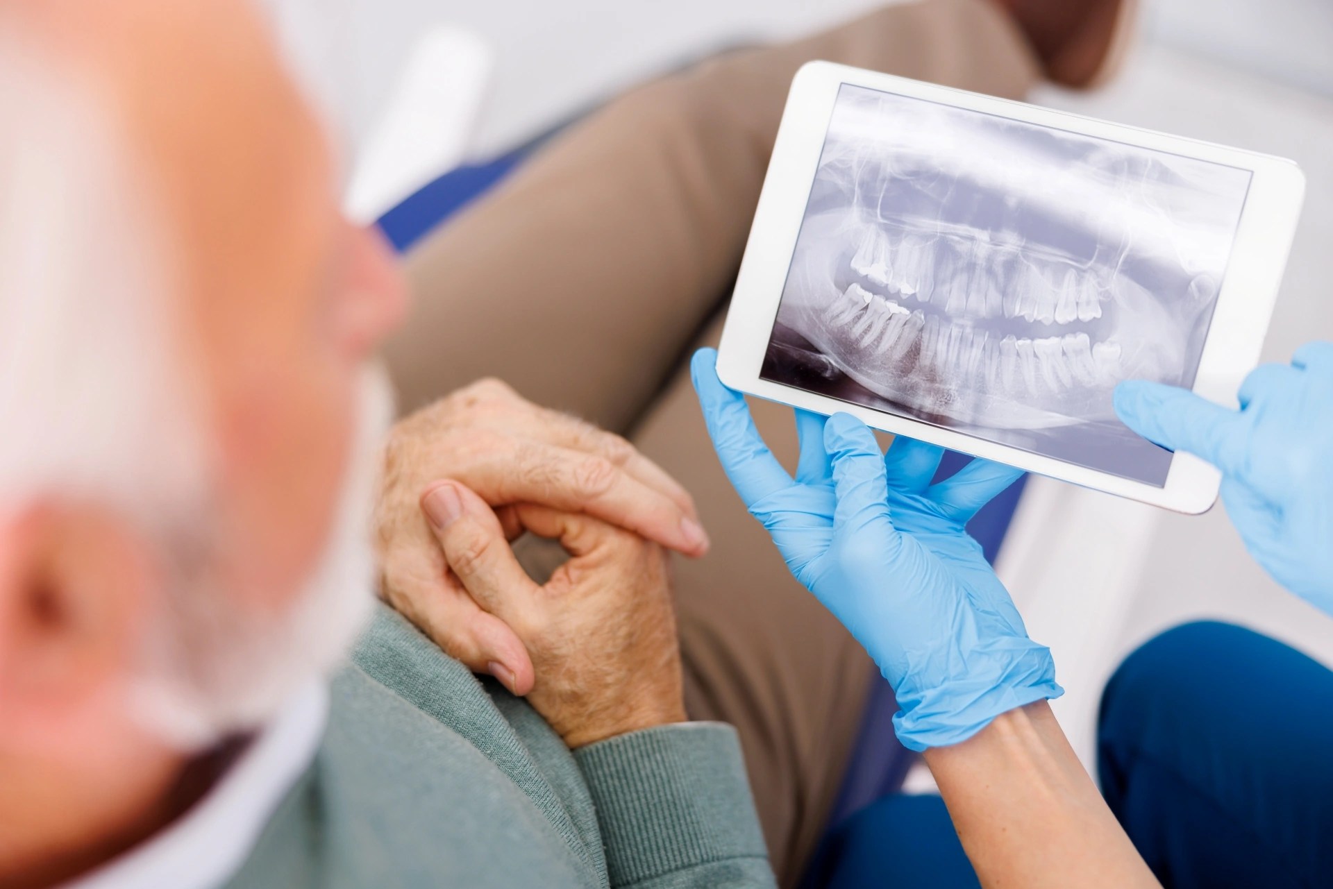 Dentist reviewing a panoramic dental X-ray with a patient during an implant consultation