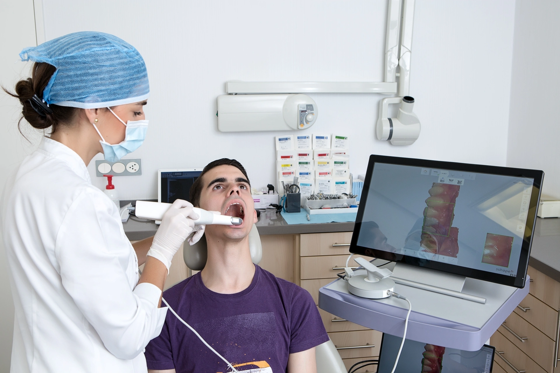 Oral surgeon using digital imaging technology to evaluate a patient's teeth and jaw.