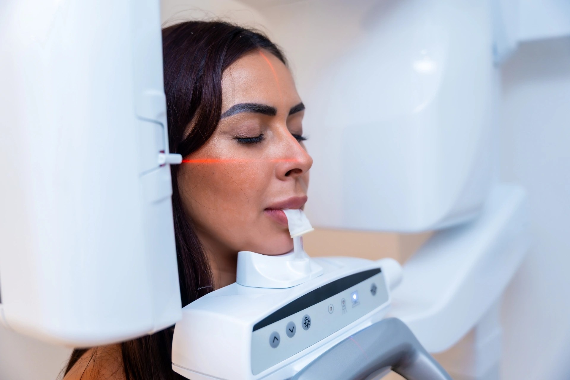 Patient positioned for 3D dental imaging during an oral surgery scan.