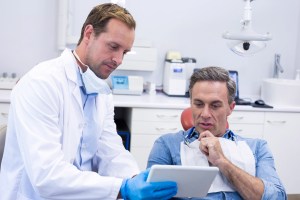 Oral surgeon discussing dental implant treatment with a patient.